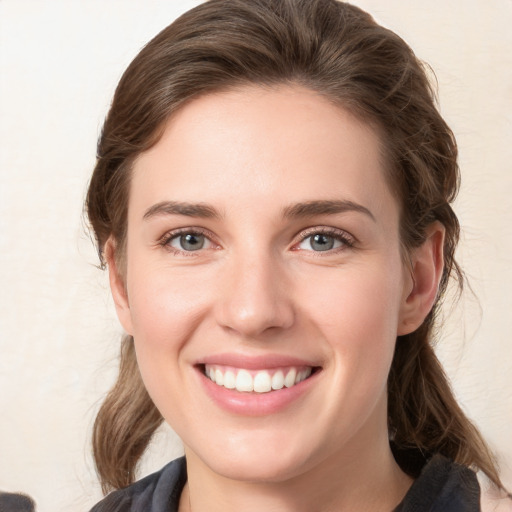 Joyful white young-adult female with medium  brown hair and grey eyes