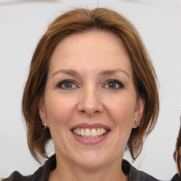 Joyful white adult female with medium  brown hair and grey eyes