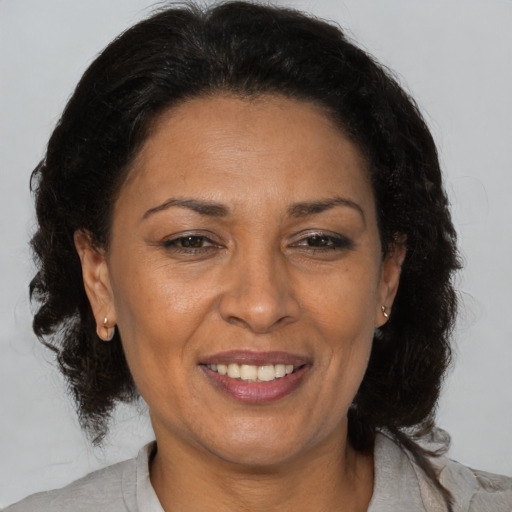 Joyful latino adult female with medium  brown hair and brown eyes