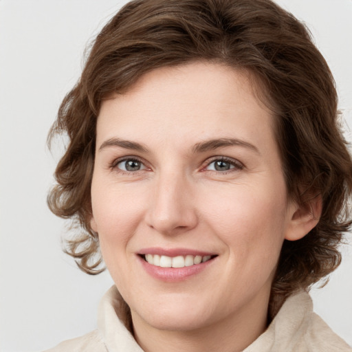 Joyful white young-adult female with medium  brown hair and green eyes