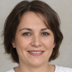 Joyful white adult female with medium  brown hair and brown eyes