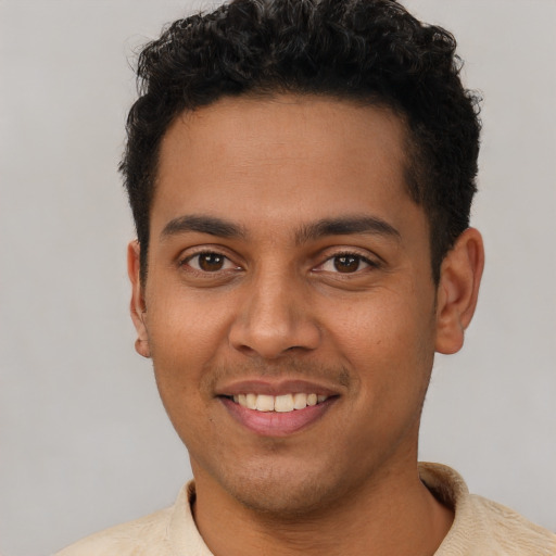 Joyful latino young-adult male with short  brown hair and brown eyes