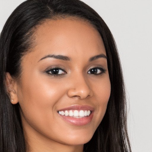 Joyful latino young-adult female with long  brown hair and brown eyes