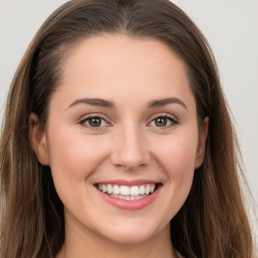 Joyful white young-adult female with long  brown hair and grey eyes