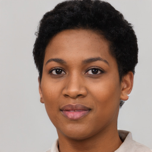 Joyful black young-adult female with short  black hair and brown eyes
