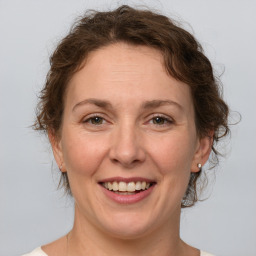 Joyful white adult female with medium  brown hair and grey eyes