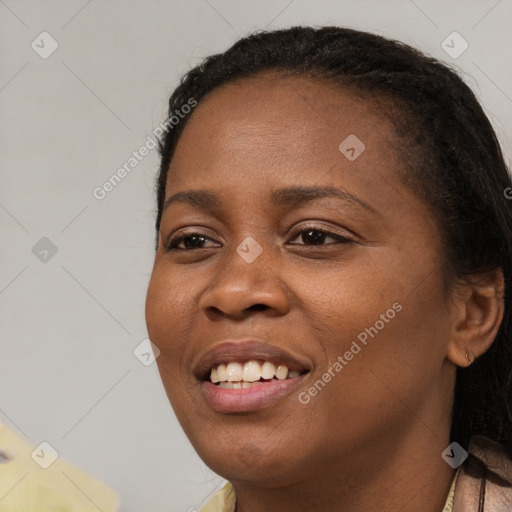 Joyful black young-adult female with long  brown hair and brown eyes