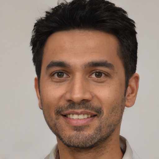 Joyful white young-adult male with short  black hair and brown eyes