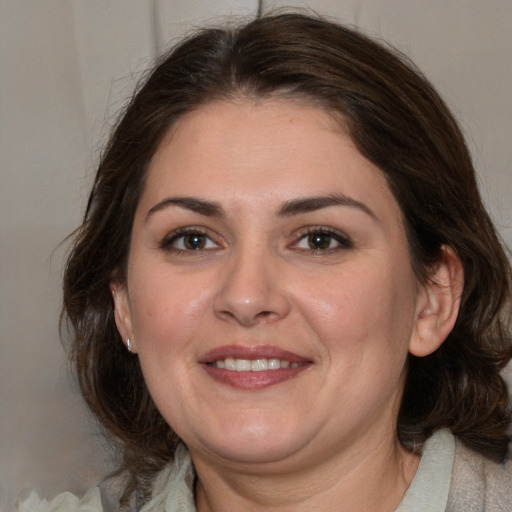 Joyful white adult female with medium  brown hair and brown eyes