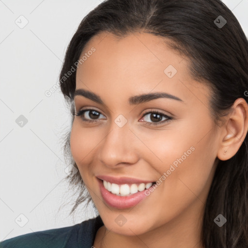 Joyful latino young-adult female with long  brown hair and brown eyes