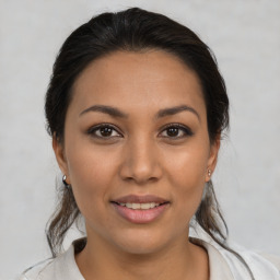 Joyful latino young-adult female with medium  brown hair and brown eyes