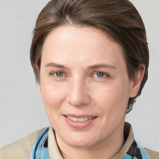 Joyful white adult female with medium  brown hair and grey eyes