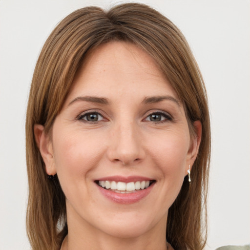 Joyful white young-adult female with medium  brown hair and green eyes