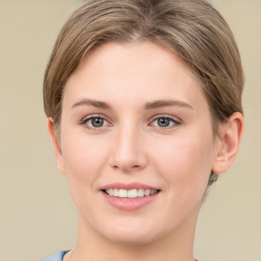 Joyful white young-adult female with short  brown hair and grey eyes