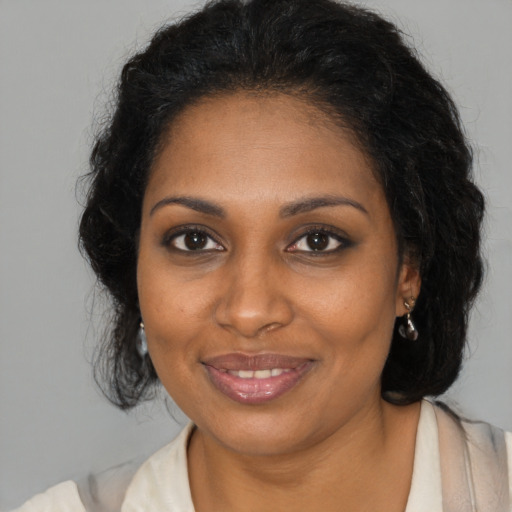 Joyful black young-adult female with medium  brown hair and brown eyes