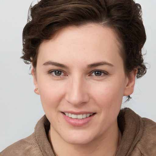 Joyful white young-adult female with short  brown hair and grey eyes