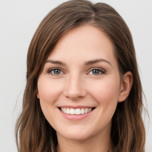 Joyful white young-adult female with long  brown hair and green eyes