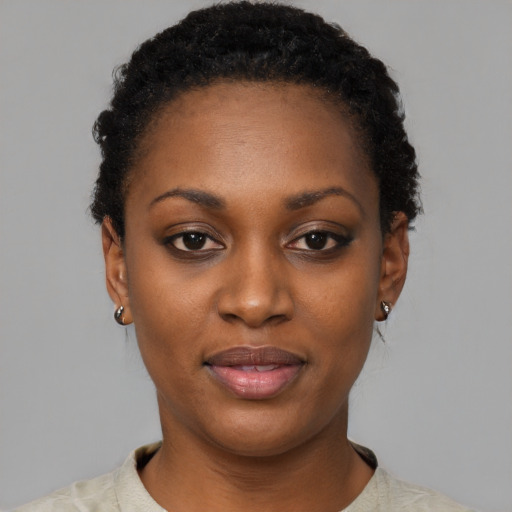 Joyful black young-adult female with short  black hair and brown eyes