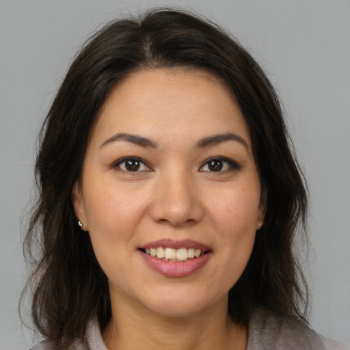 Joyful latino young-adult female with medium  brown hair and brown eyes