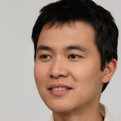 Joyful asian young-adult male with short  black hair and brown eyes