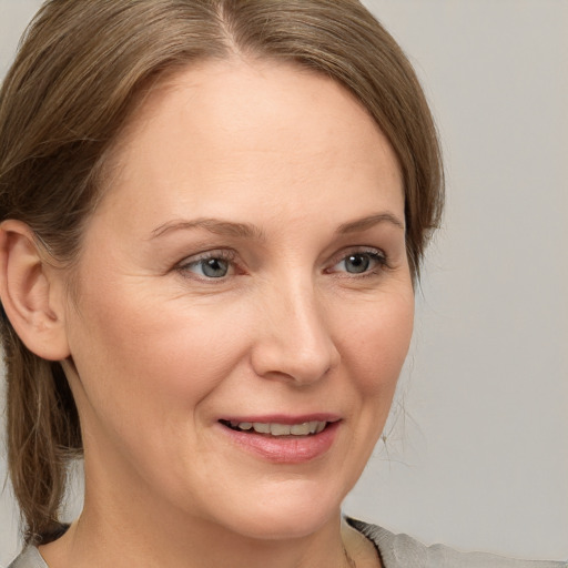 Joyful white adult female with medium  brown hair and grey eyes