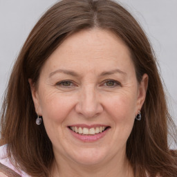 Joyful white adult female with long  brown hair and grey eyes