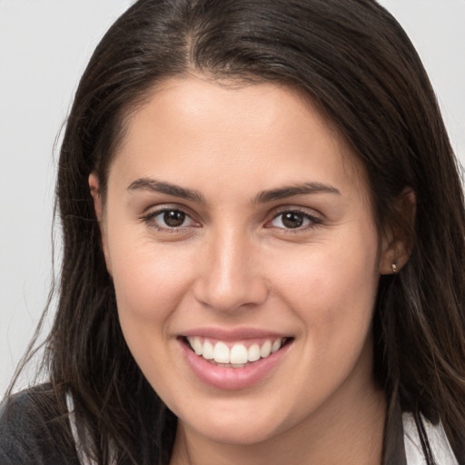 Joyful white young-adult female with long  brown hair and brown eyes