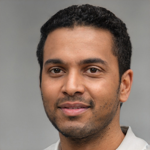 Joyful black young-adult male with short  black hair and brown eyes