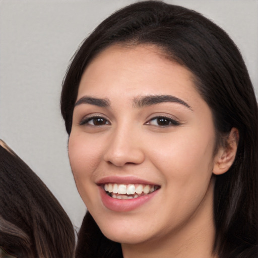 Joyful white young-adult female with long  black hair and brown eyes