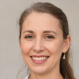 Joyful white adult female with long  brown hair and brown eyes