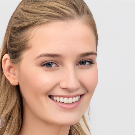 Joyful white young-adult female with long  brown hair and blue eyes