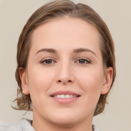 Joyful white young-adult female with medium  brown hair and grey eyes