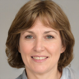 Joyful white adult female with medium  brown hair and grey eyes