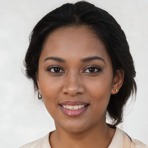 Joyful black young-adult female with medium  brown hair and brown eyes