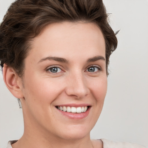 Joyful white young-adult female with short  brown hair and grey eyes