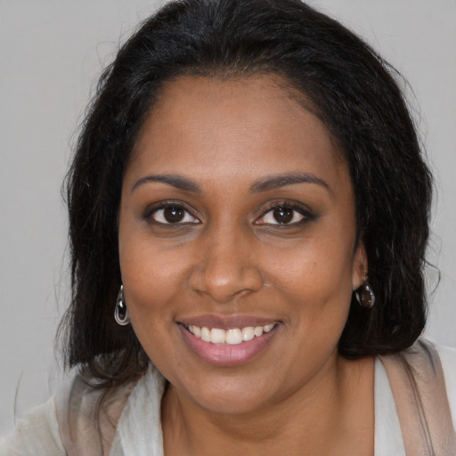 Joyful black young-adult female with medium  brown hair and brown eyes