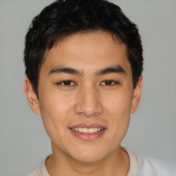 Joyful asian young-adult male with short  brown hair and brown eyes