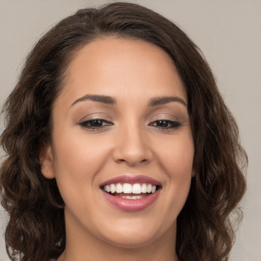 Joyful white young-adult female with long  brown hair and brown eyes