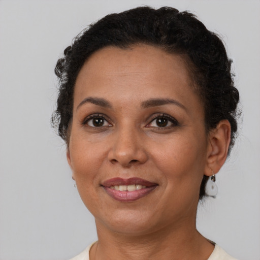 Joyful latino adult female with short  brown hair and brown eyes