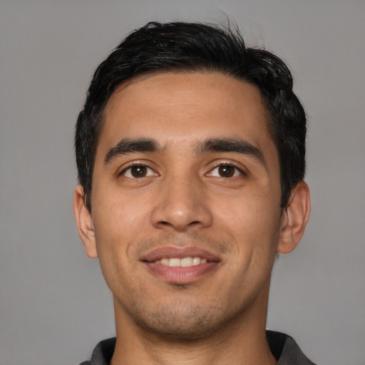Joyful latino young-adult male with short  black hair and brown eyes
