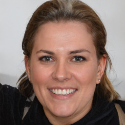 Joyful white adult female with medium  brown hair and brown eyes