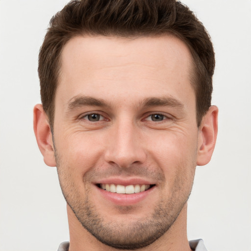 Joyful white young-adult male with short  brown hair and grey eyes