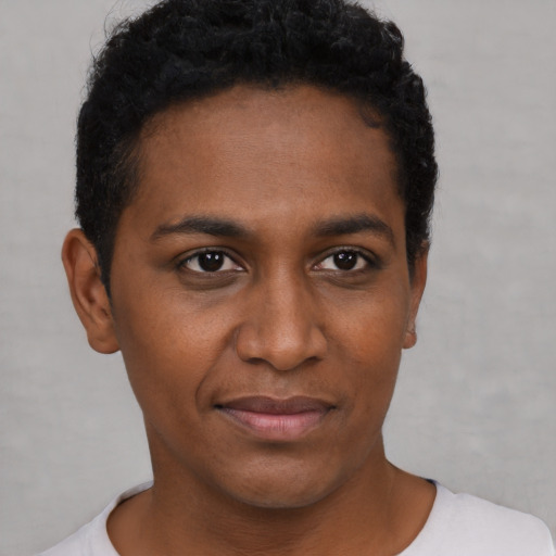 Joyful black young-adult female with short  black hair and brown eyes