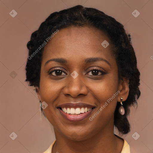 Joyful black young-adult female with long  black hair and brown eyes