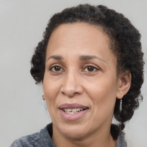 Joyful black adult female with short  brown hair and brown eyes