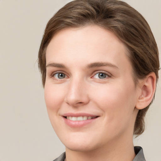 Joyful white young-adult female with medium  brown hair and grey eyes