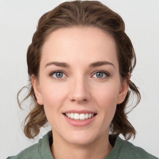 Joyful white young-adult female with medium  brown hair and green eyes