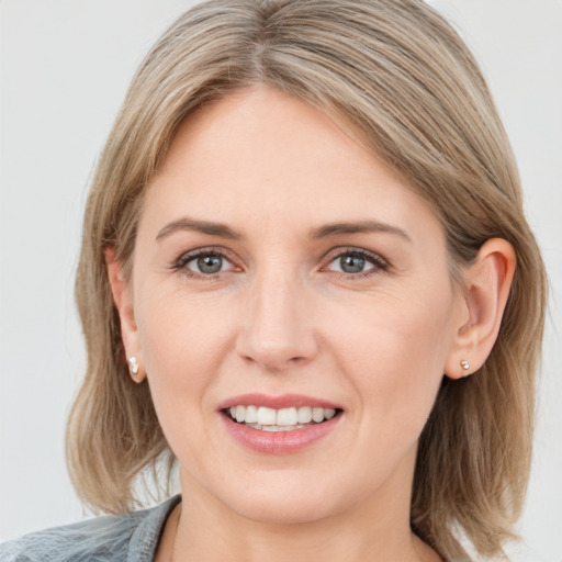 Joyful white young-adult female with medium  brown hair and blue eyes