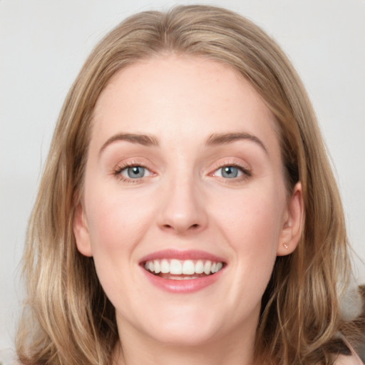 Joyful white young-adult female with medium  brown hair and blue eyes