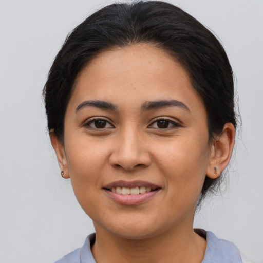 Joyful latino young-adult female with medium  brown hair and brown eyes